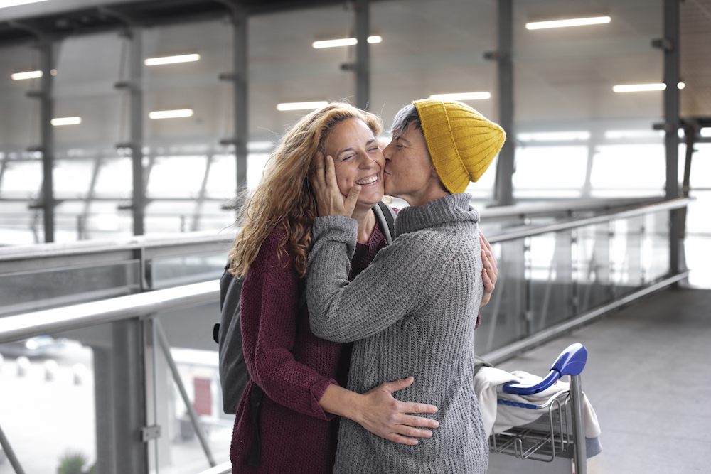 Solo traveler embracing a friend or upon returning home from Europe.